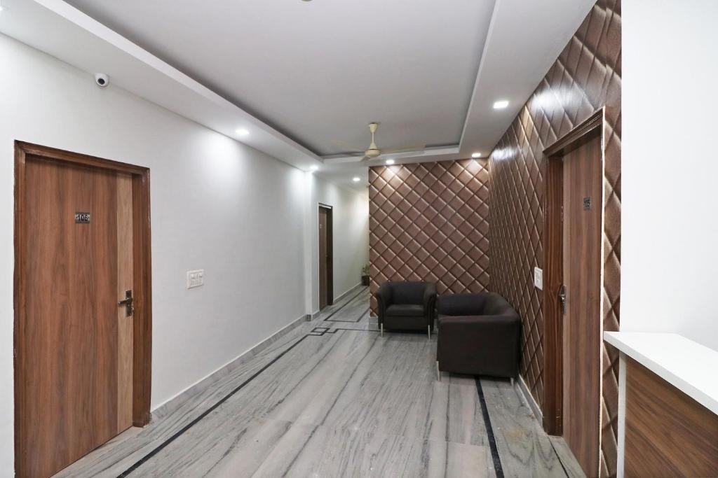 a hallway with a room with a chair and a door at Capital O Esscon House Near Payal Cinema in Gurgaon