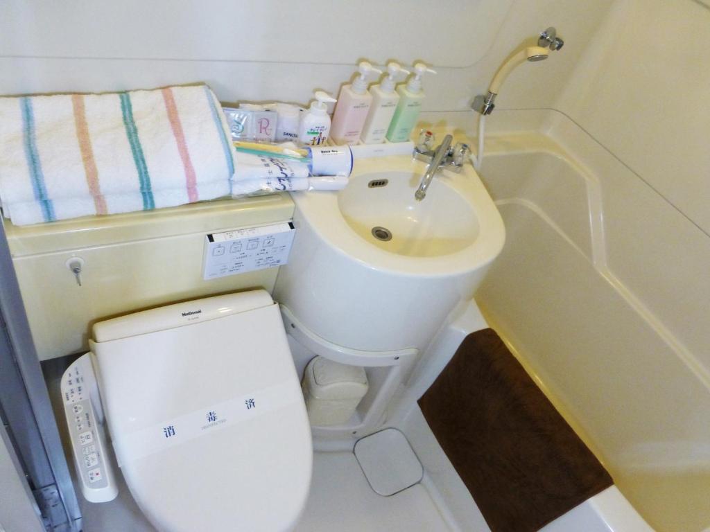 une petite salle de bain avec toilettes et lavabo dans l'établissement Kawaguchiko Lakeside Hotel, à Fujikawaguchiko