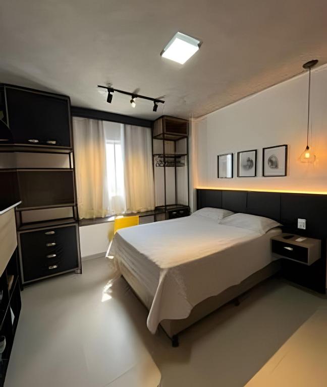 a bedroom with a bed and a flat screen tv at Studio Estilo Industrial - 01 - BARRETO - in Mossoró