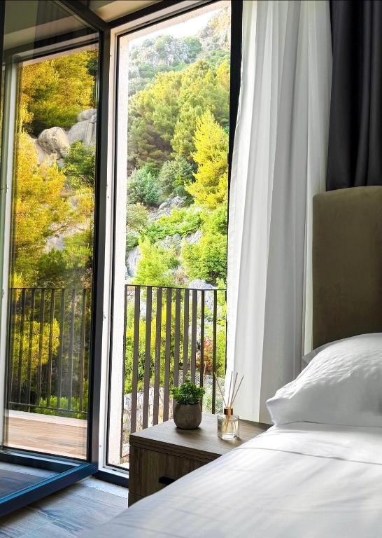 a bedroom with a bed and a large window at Villa Blanc in Shëngjin