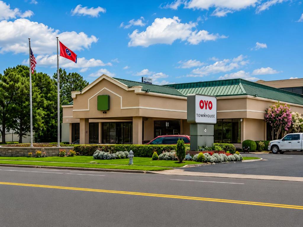 a qo office building with a qo sign in front at Gardentree Hotels Memphis East near I 40 in Memphis