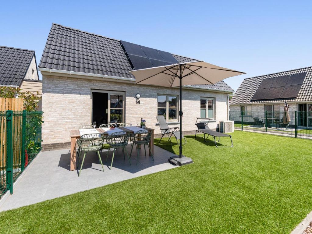 a patio with a table and an umbrella at Westhinder II H14 in Koksijde