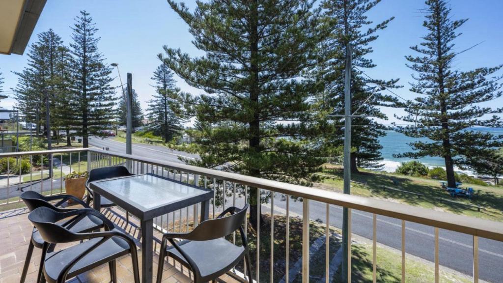 a balcony with chairs and a table and a view of the ocean at Flinders Lodge Unit 5 - Lifestyle Yamba in Yamba