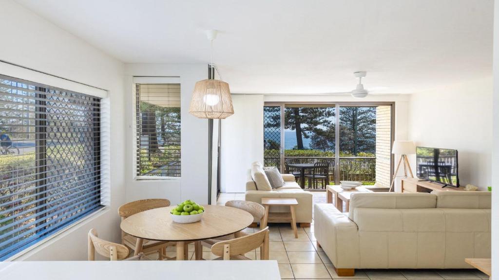 a living room with a couch and a table at Flinders Lodge Unit 1 - Lifestyle Yamba in Yamba