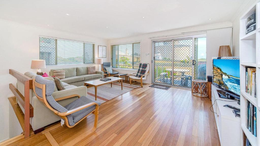 a living room with a couch and a table at Lighthouse Unit 1 - Lifestyle Yamba in Yamba