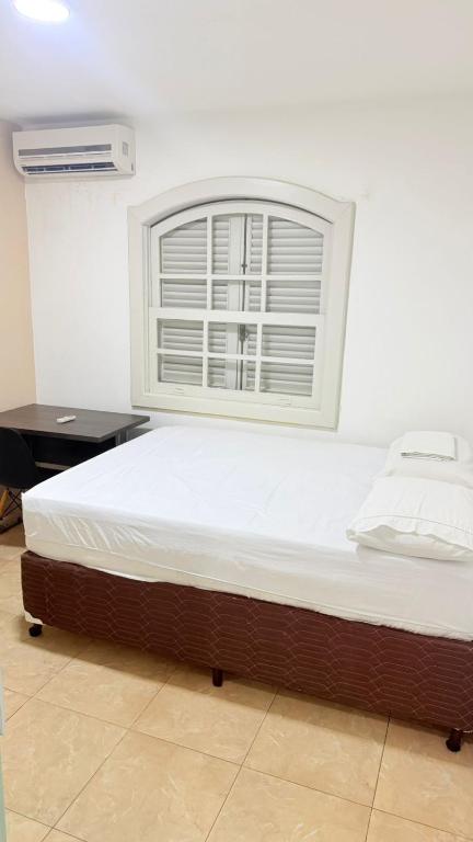 ein Bett in einem Zimmer mit Fenster in der Unterkunft Bella Playa in Cabo Frio