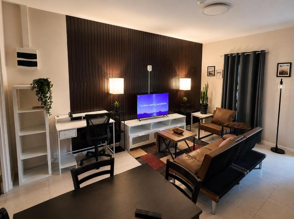 un soggiorno con divano e televisore di Spacious 1-BR Studio with Fast WIFI l Work-Friendly Stay a Paramaribo