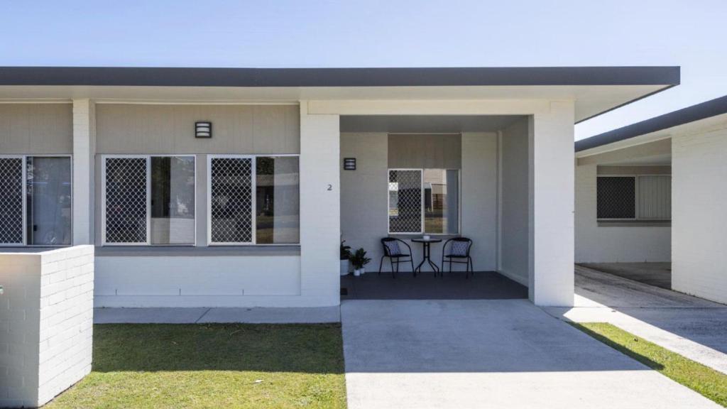a small white house with a table and chairs at Sunnyvale 2 - Lifestyle Yamba in Yamba
