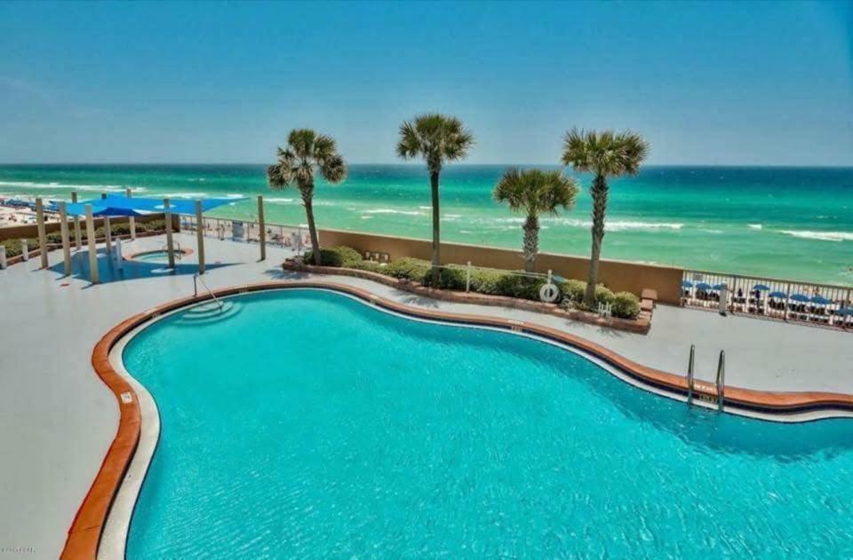 a swimming pool with the ocean in the background at Blue Heron Beach Front in Panama City Beach