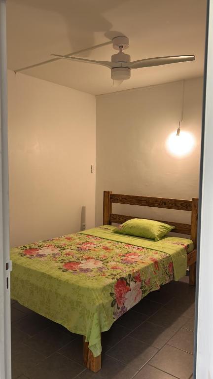 a bedroom with a bed and a ceiling fan at Villa SCAYOU in Pointe-Noire