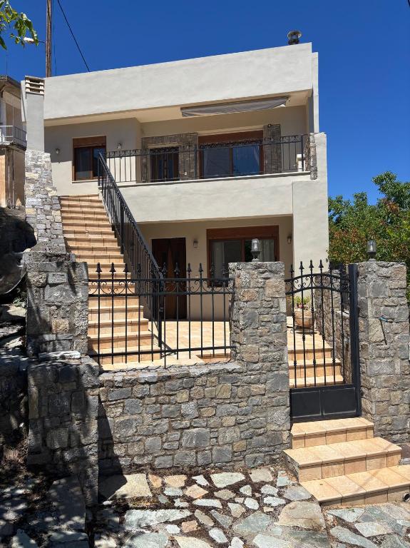 a house with a stone wall and stairs at Psichro Apartments Hera in Magoulás