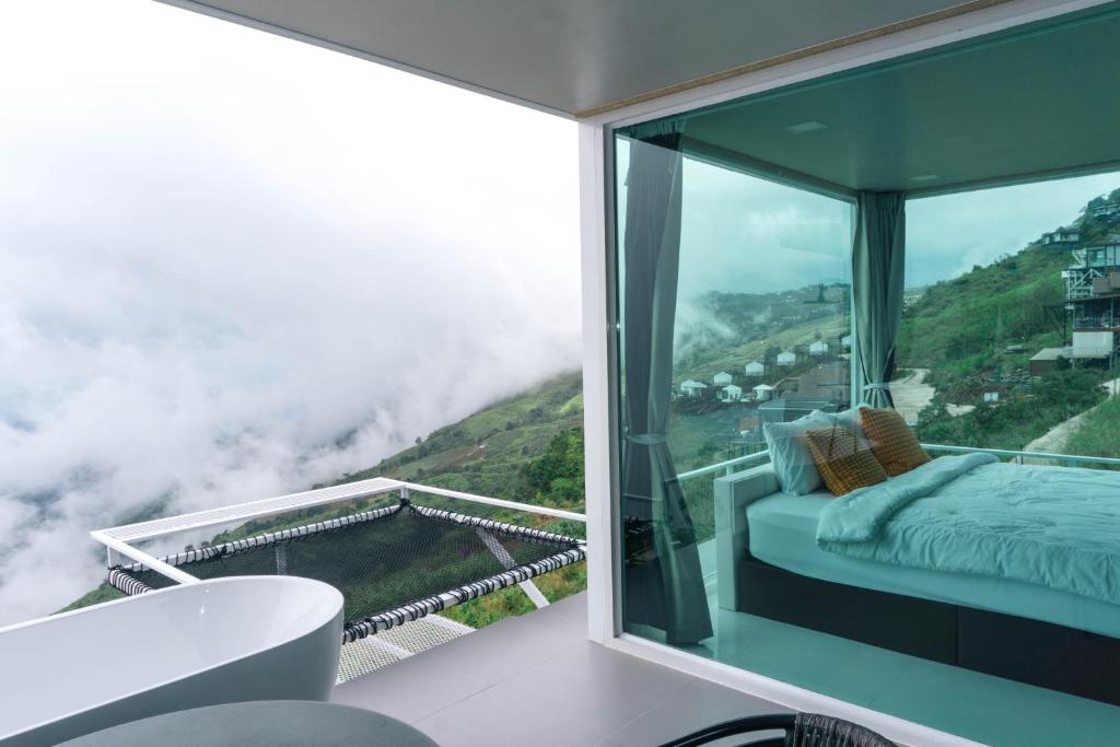 a bedroom with a bed and a view of a mountain at ม่อนทับเบิก รีสอร์ท ภูทับเบิก in Ban Maeo Thap Boek