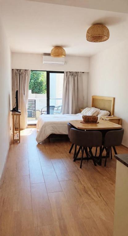 a bedroom with a bed and a table in it at Hermoso departamento Saavedra 4741 in Buenos Aires