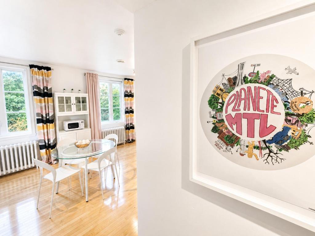 a dining room with a table and a picture on the wall at Appartements Saint-Alexandre in Longueuil