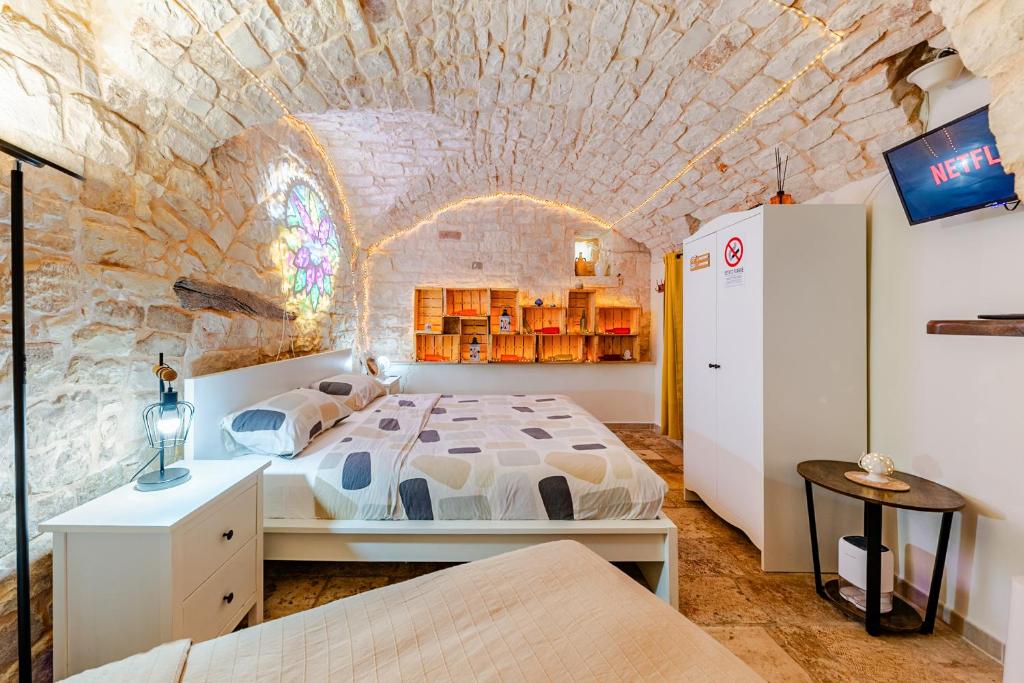 a bedroom with a large bed in a brick wall at Vitti Stone House - Centro Storico Castellana in Castellana Grotte