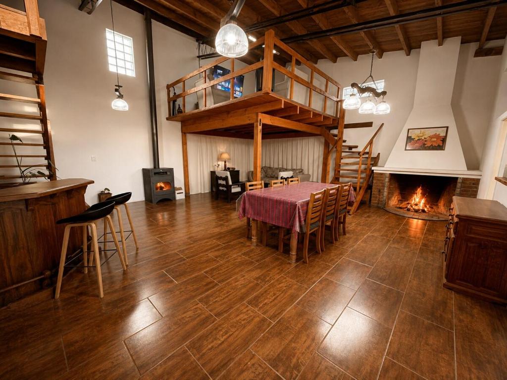 a large room with a table and a fireplace at El Refugio de la Trochita in Esquel