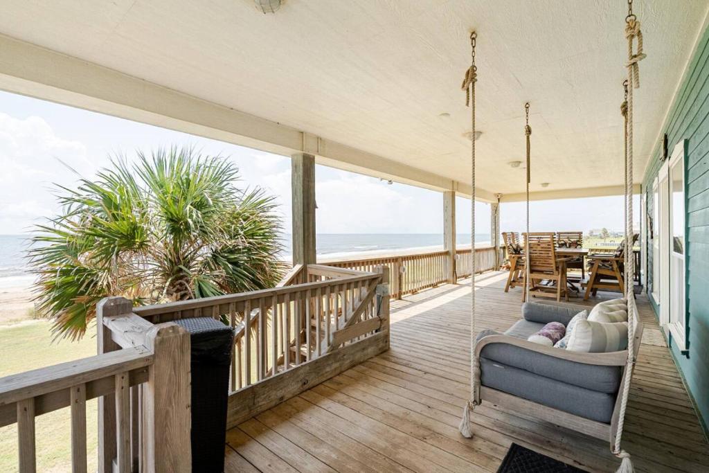 a porch with a swing and a view of the ocean at Beachfront Fire Pit Gourmet Kitchen Views in Bolivar Peninsula
