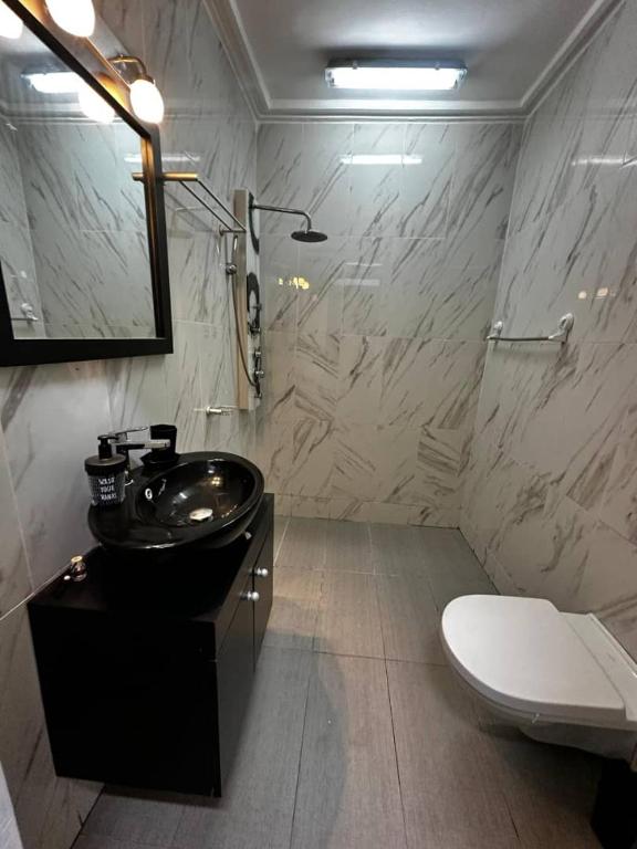 a bathroom with a black sink and a toilet at Villa 49 in Abidjan
