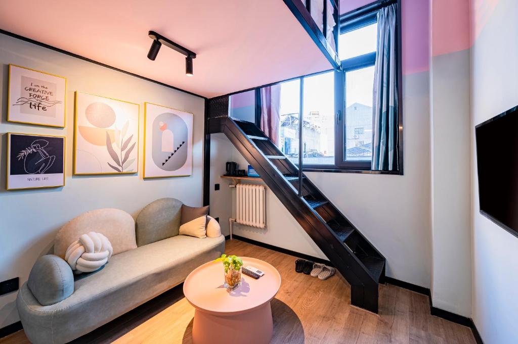 a living room with a couch and a staircase at Beijing xiyou hotel in Beijing
