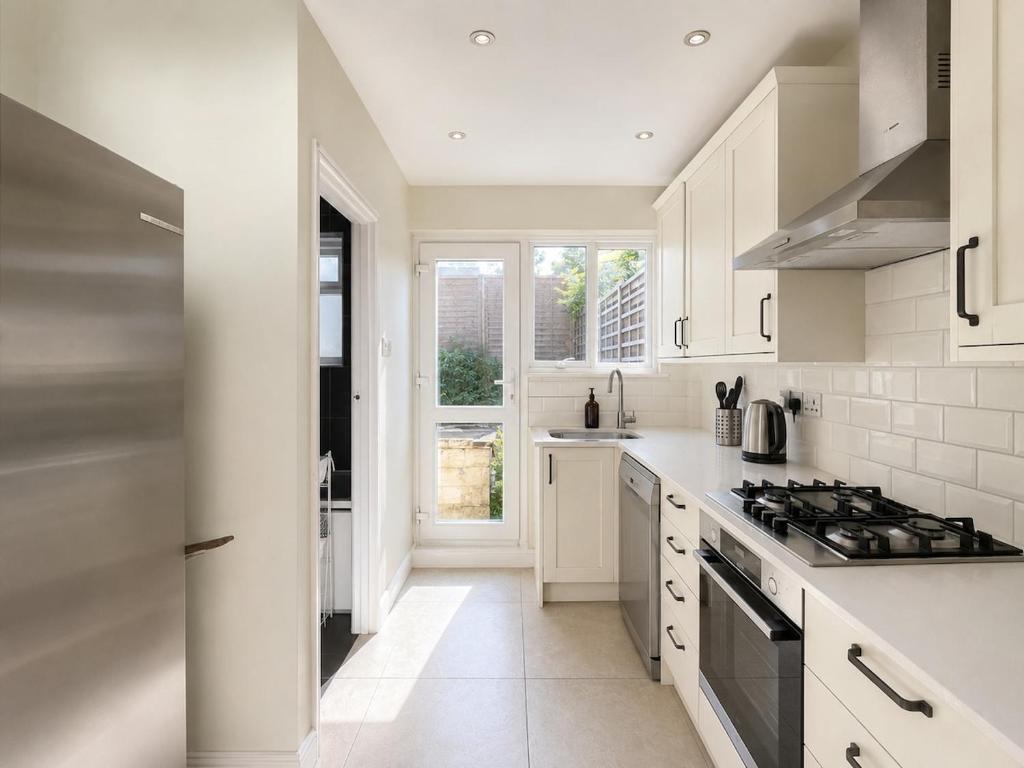 a kitchen with white cabinets and a stove top oven at Full House - Croydon centre in Croydon