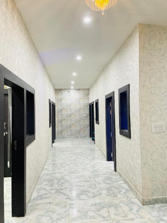 an empty hallway with doors and a tile floor at Hotel Maatrika and banquets in Orchha