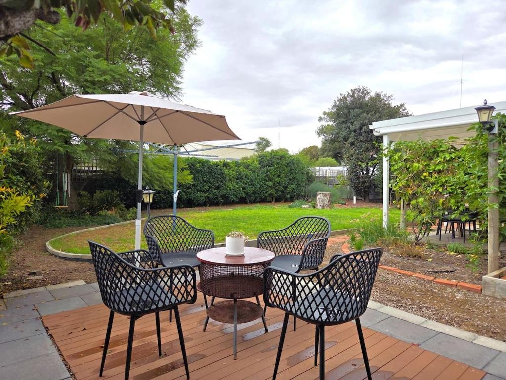 a table and chairs with an umbrella on a patio at Cosy Cottage in Port Broughton