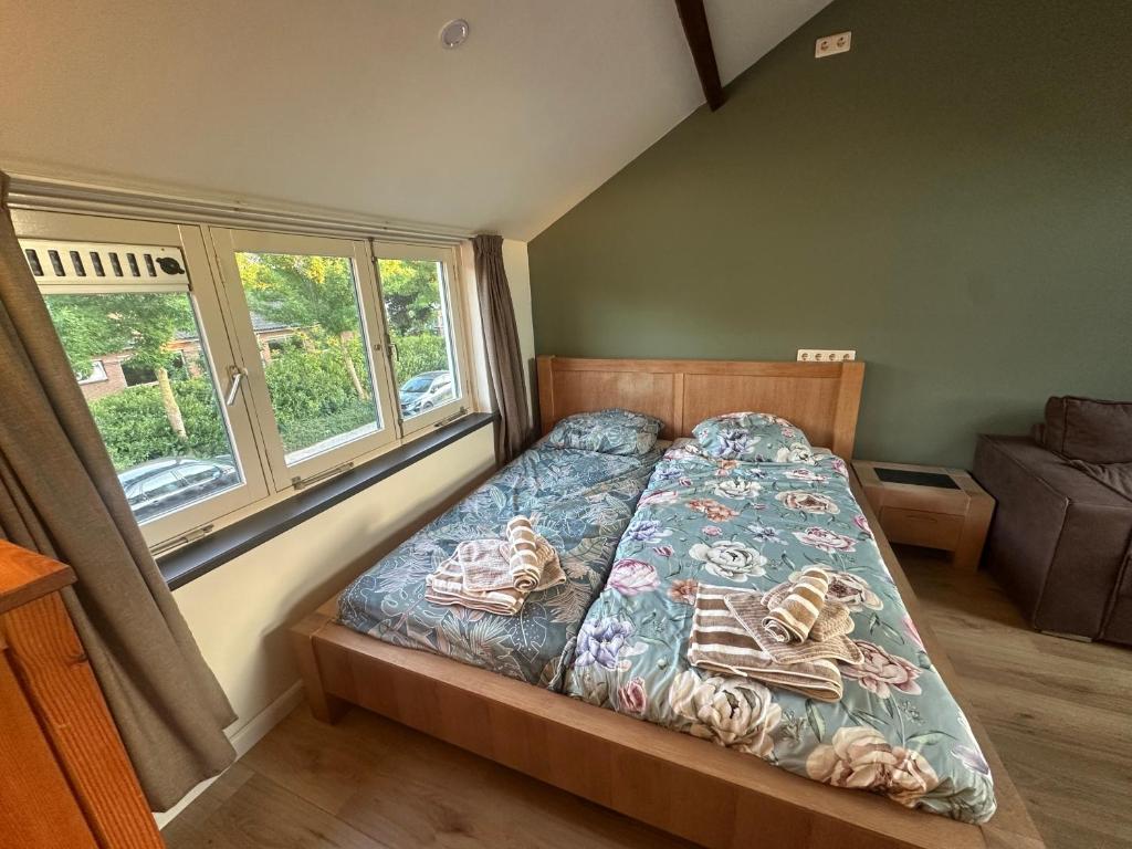 a bedroom with a bed and a window at Tim's Place in Groesbeek