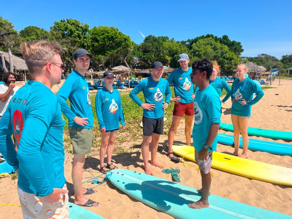 a group of people standing on a beach with surfboards at Saha surf camp lesson booking only in Pottuvil