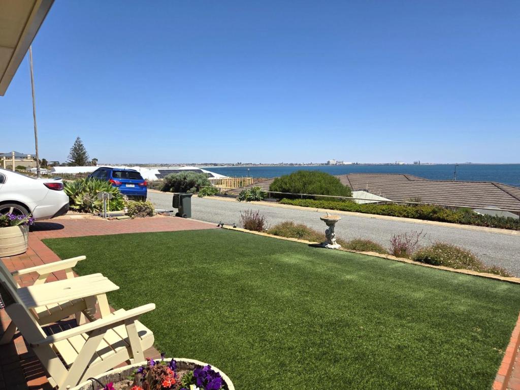 a lawn with a bench and a view of the ocean at Willenby in Wallaroo