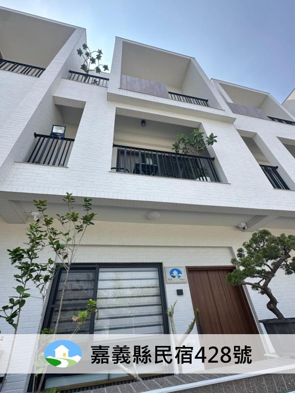 a white building with windows and a door at 喜滿家民宿 in Zhuqi