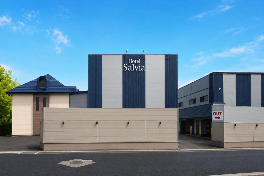 a building with a sign on the side of it at ホテルサルビア in Tendo