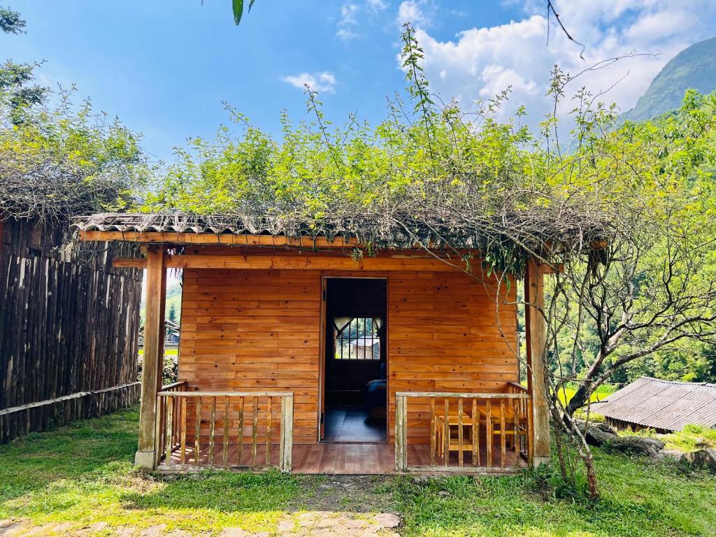 a small log cabin with a porch and a door at B & M Homes in Tả Van
