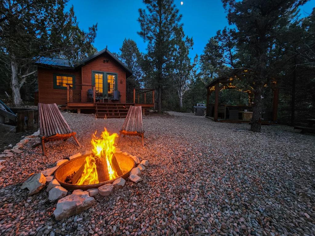 a fire pit in front of a log cabin at Live Simply Cabin, Walking distance to East Zion trails in Orderville
