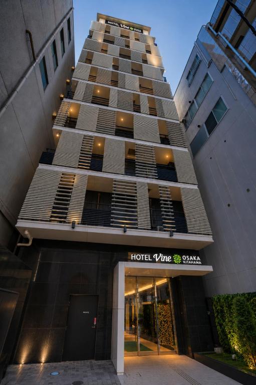 a tall building with a hotel v line sign in front at HOTEL VINE OSAKA KITAHAMA in Osaka