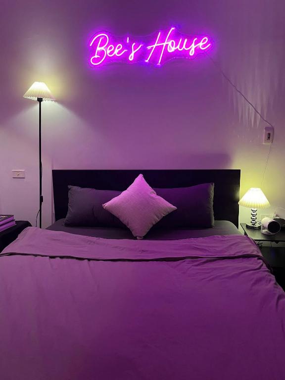 a bedroom with a bed with a pink neon sign at Bee's House in Hanoi