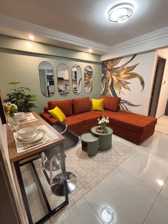 a living room with a couch and a table at Serenity Spot - Cozy 1 bedroom with AC and Heater with City View in Nairobi, Westlands in Nairobi