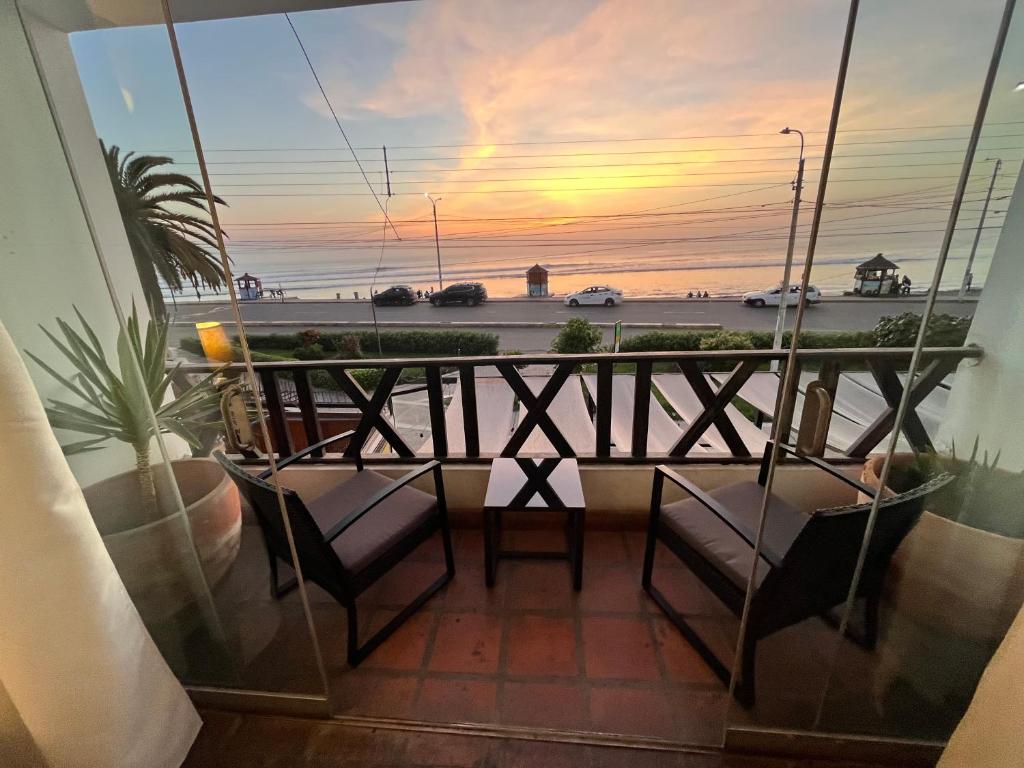 a balcony with two chairs and a view of the ocean at Club Colonial Hotel in Huanchaco