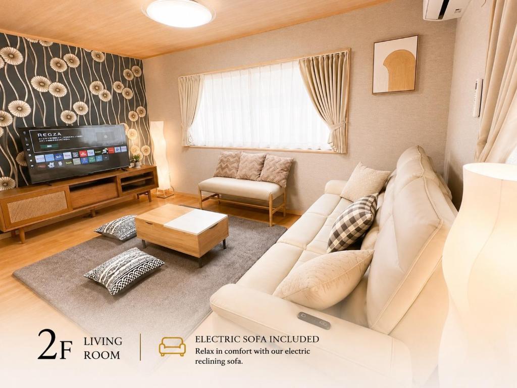 a living room with a white couch and a tv at 関口ロイヤルハウス in Tokyo