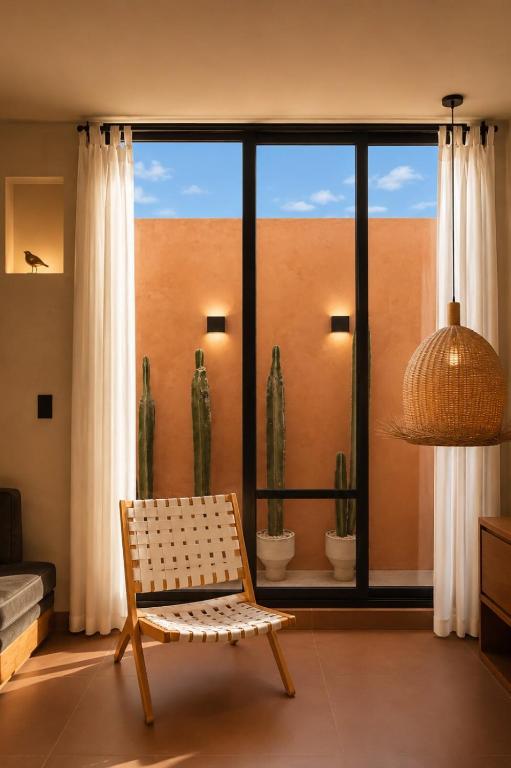 a living room with a chair and a large window at Ciruelo Tuyo in La Paz