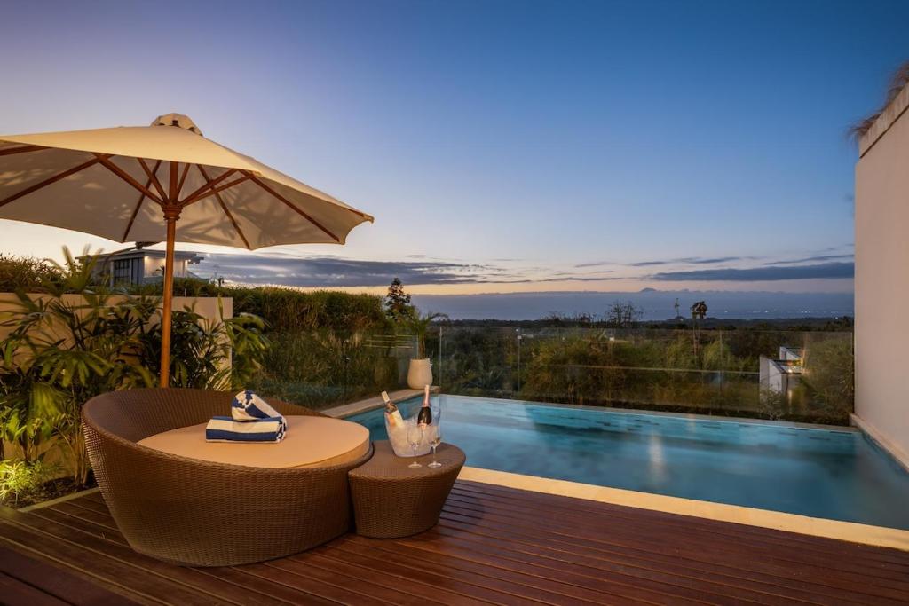 a patio with a table and an umbrella and a pool at 1BR Ocean View Villa with Private Pool - Bingin in Bingin Beach