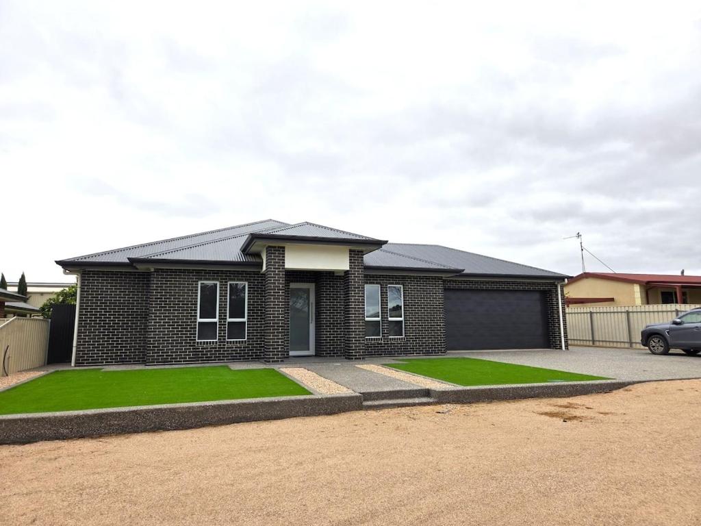 a brick house with a car parked in front of it at Belless at Moonta Bay in Port Moonta