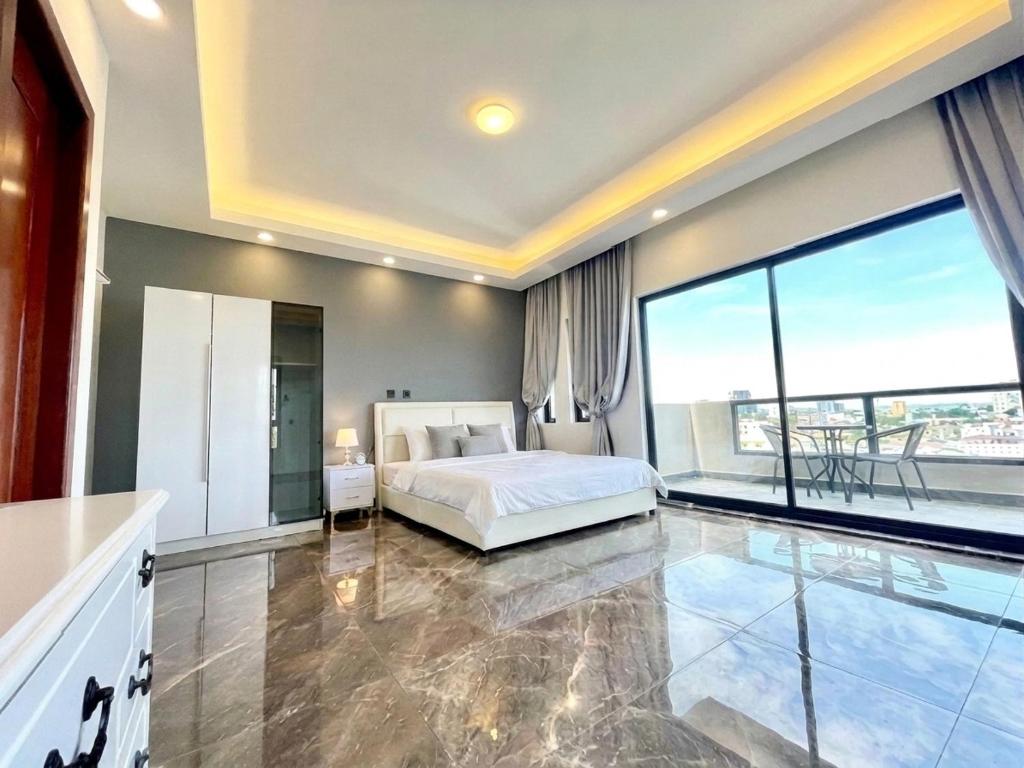 a bedroom with a bed and a large window at Sky Hotel - Cinema rooms & Apartments - Free laundry in Sihanoukville
