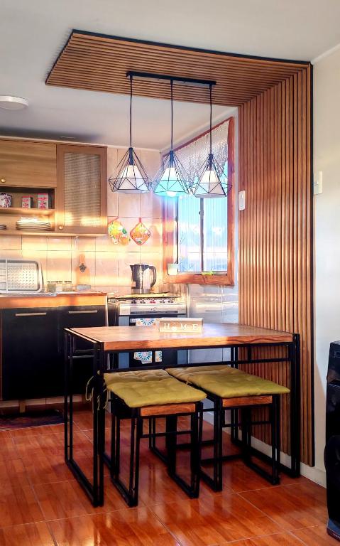 a kitchen with a table and two stools at Julieta House in Puerto Natales
