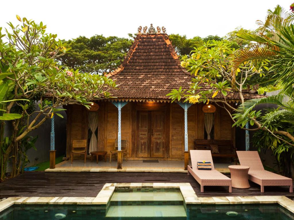 a resort with a swimming pool and a house at Joglo Villa with Private Pool in Pesanggaran