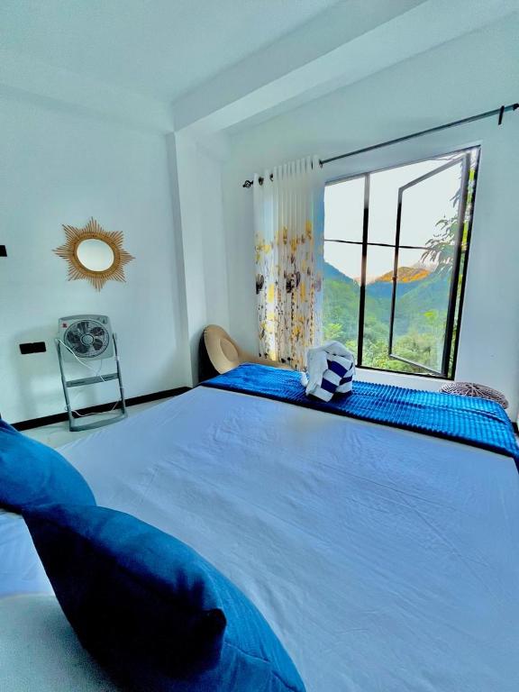 a large blue bed in a room with a window at Lavenia Mountain Holiday home in Bandarawela