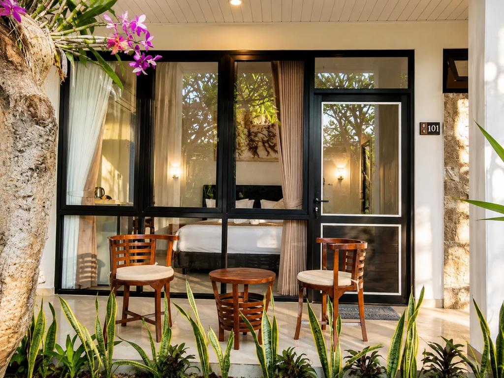 a group of chairs and a bed in a room at Pondok Biu 2 in Denpasar