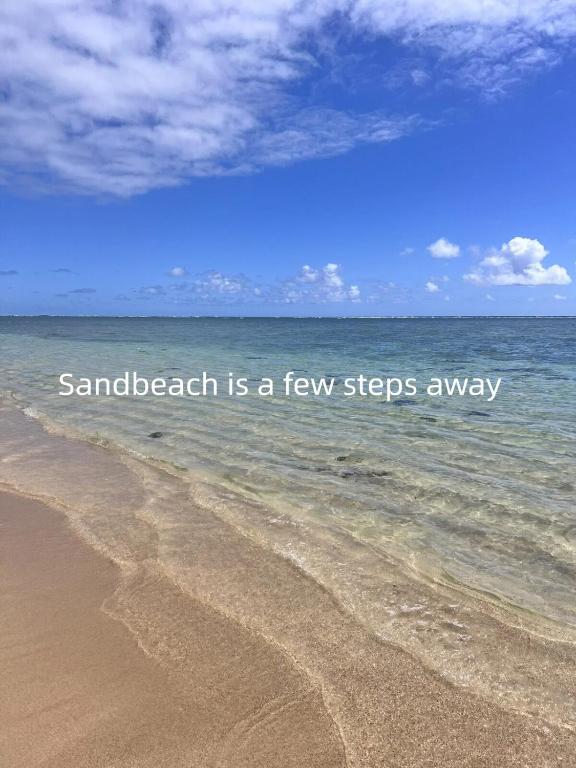 a sandy beach with the words sand beach is a few steps away at Wake Up to the Ocean - Beachfront Studio in Hauula