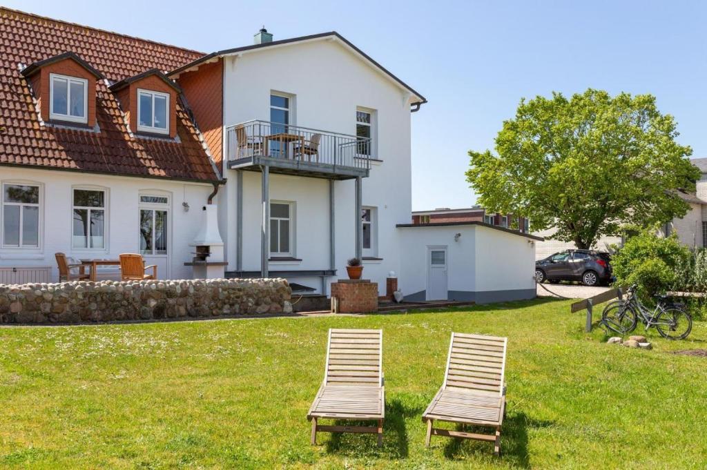 two chairs sitting in the grass in front of a house at Ille in Wittdün