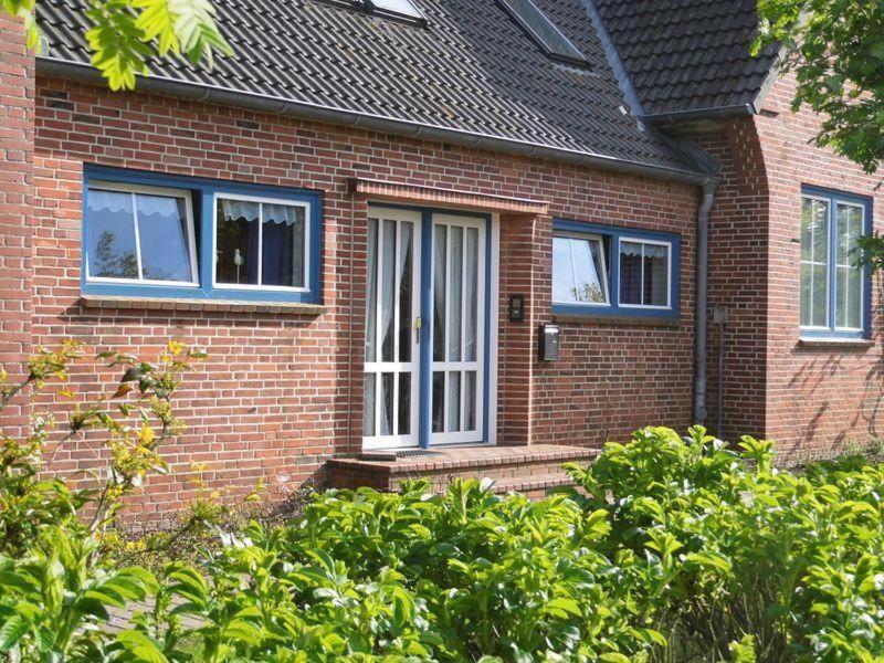 a brick house with a white door and windows at Hygge in Nebel