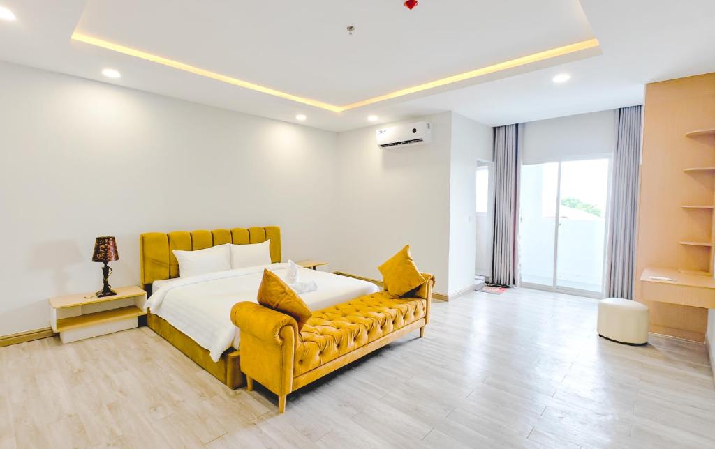 a bedroom with a bed and a yellow couch at Tiffany Resident Apartment in Siem Reap